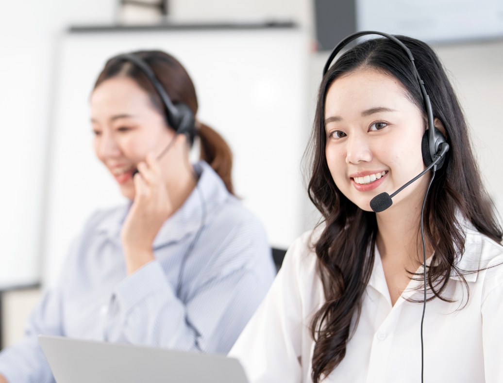 Two agents working through calls at their laptops