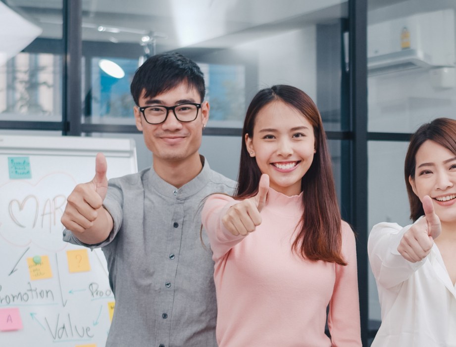 Support team giving a thumbs up in the office