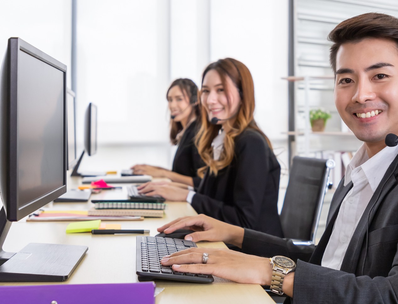 Account team working together at a shared desk