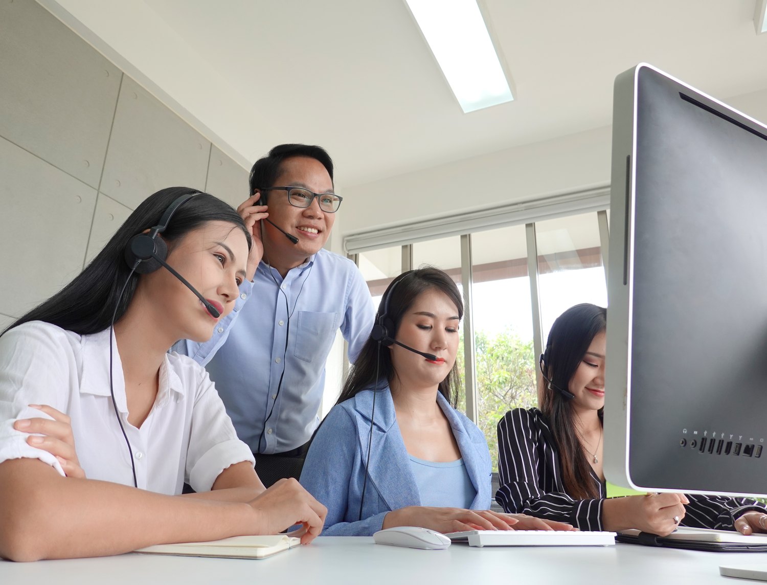 Colleagues working together at a bank of monitors
