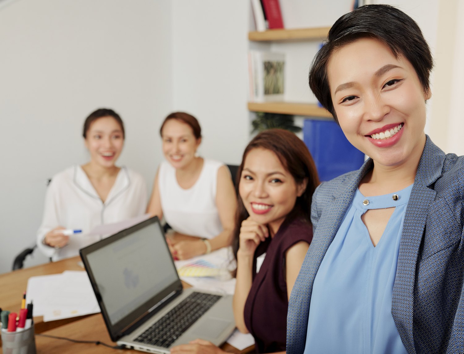 Team gathered around a laptop in a meeting