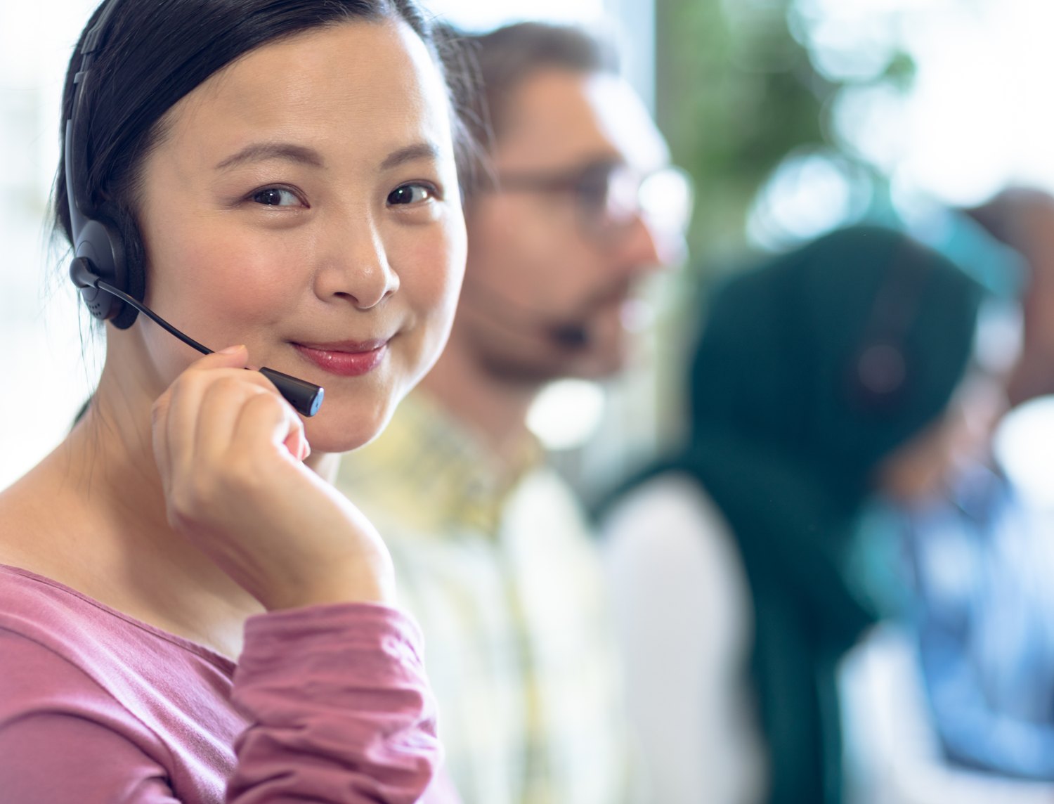 Agent on a call with colleagues working behind