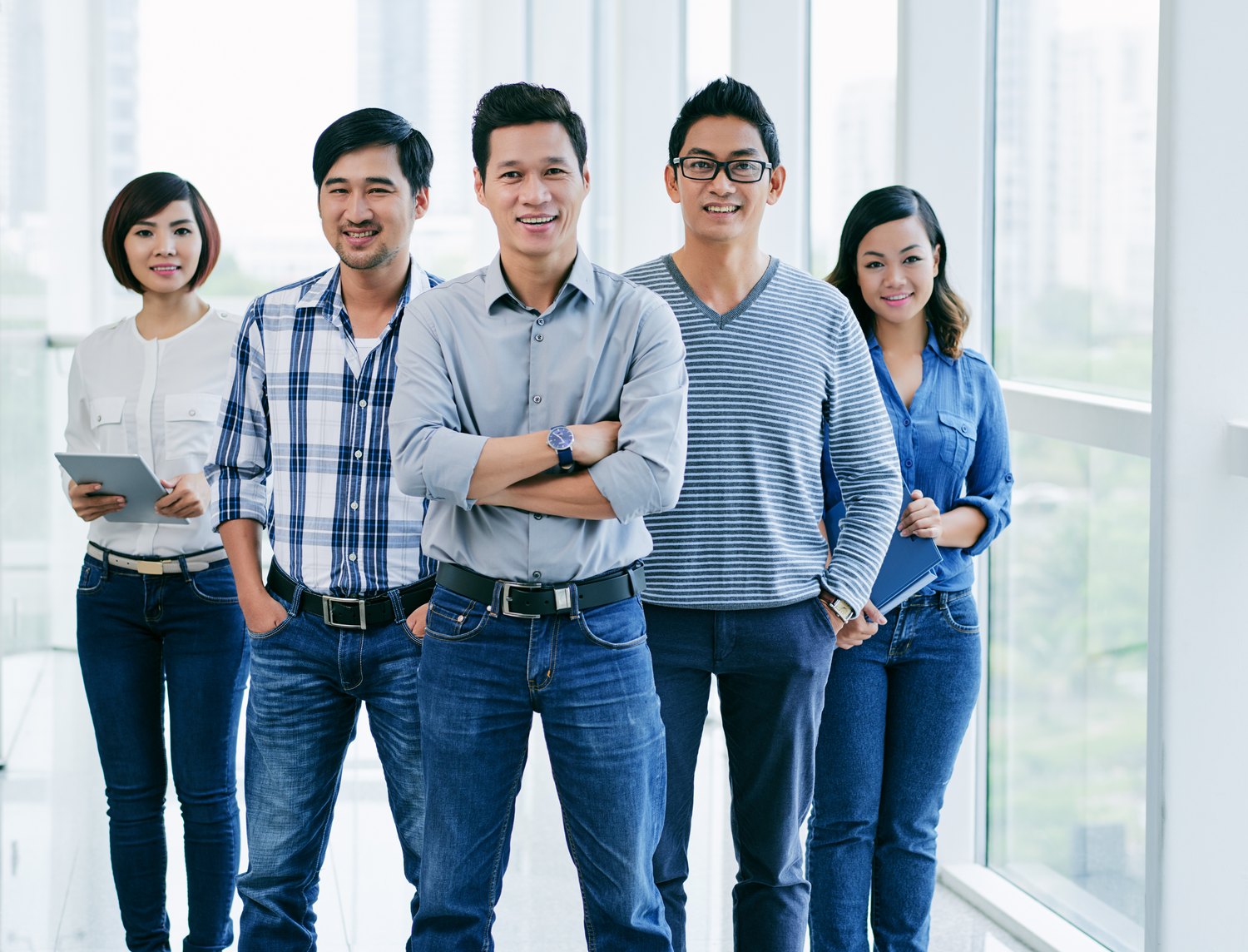 Office team standing together by a window
