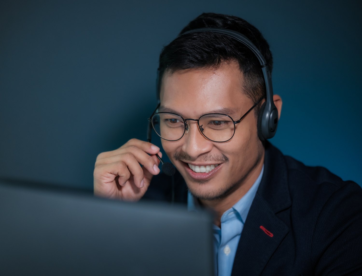 Support agent on a headset call at his desk